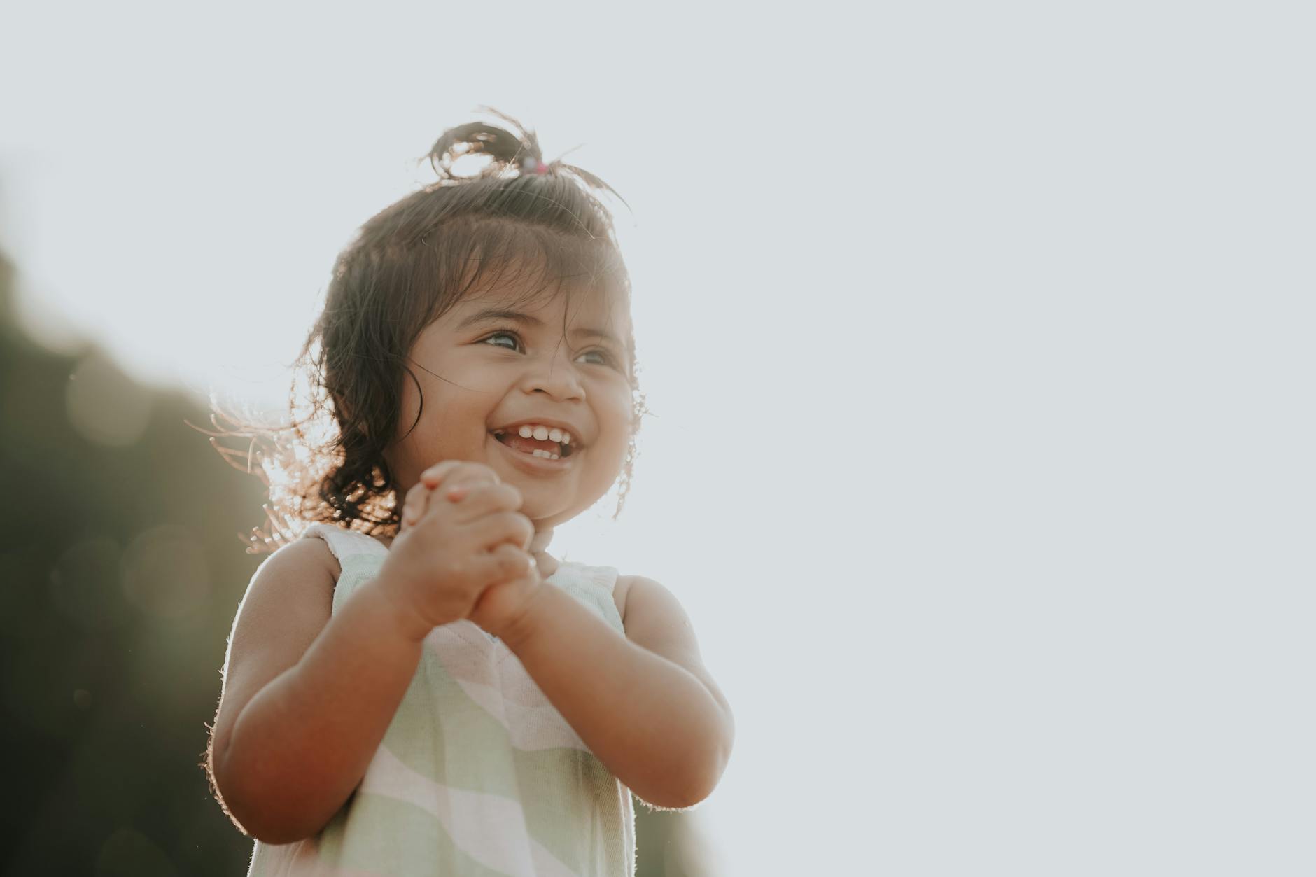 Adorable toddler smiling brightly outdoors in sunlight, depicting pure joy and innocence. - toddler tantrums outdoors