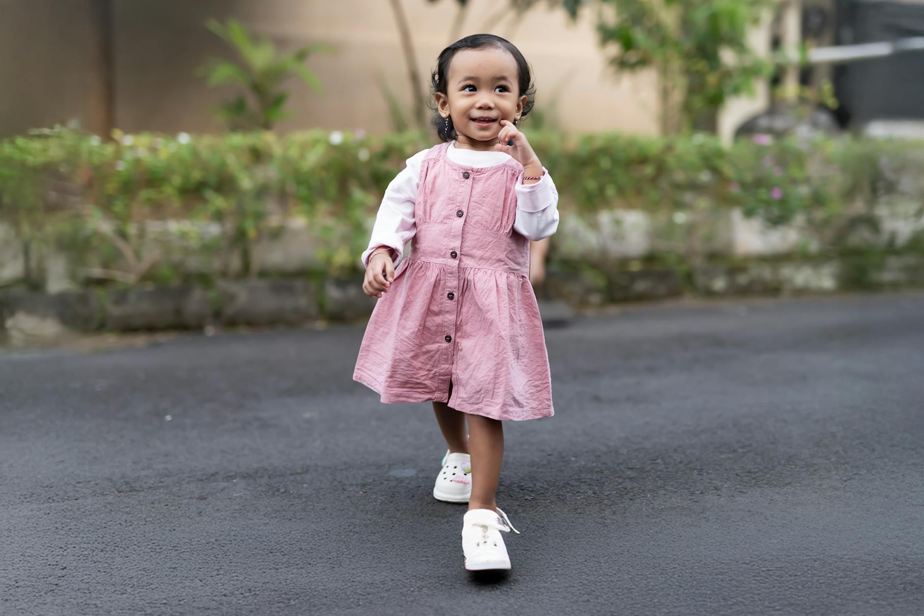 Cute child in pink dress walking confidently outside. Bright, joyful scene. - toddler tantrums outdoors