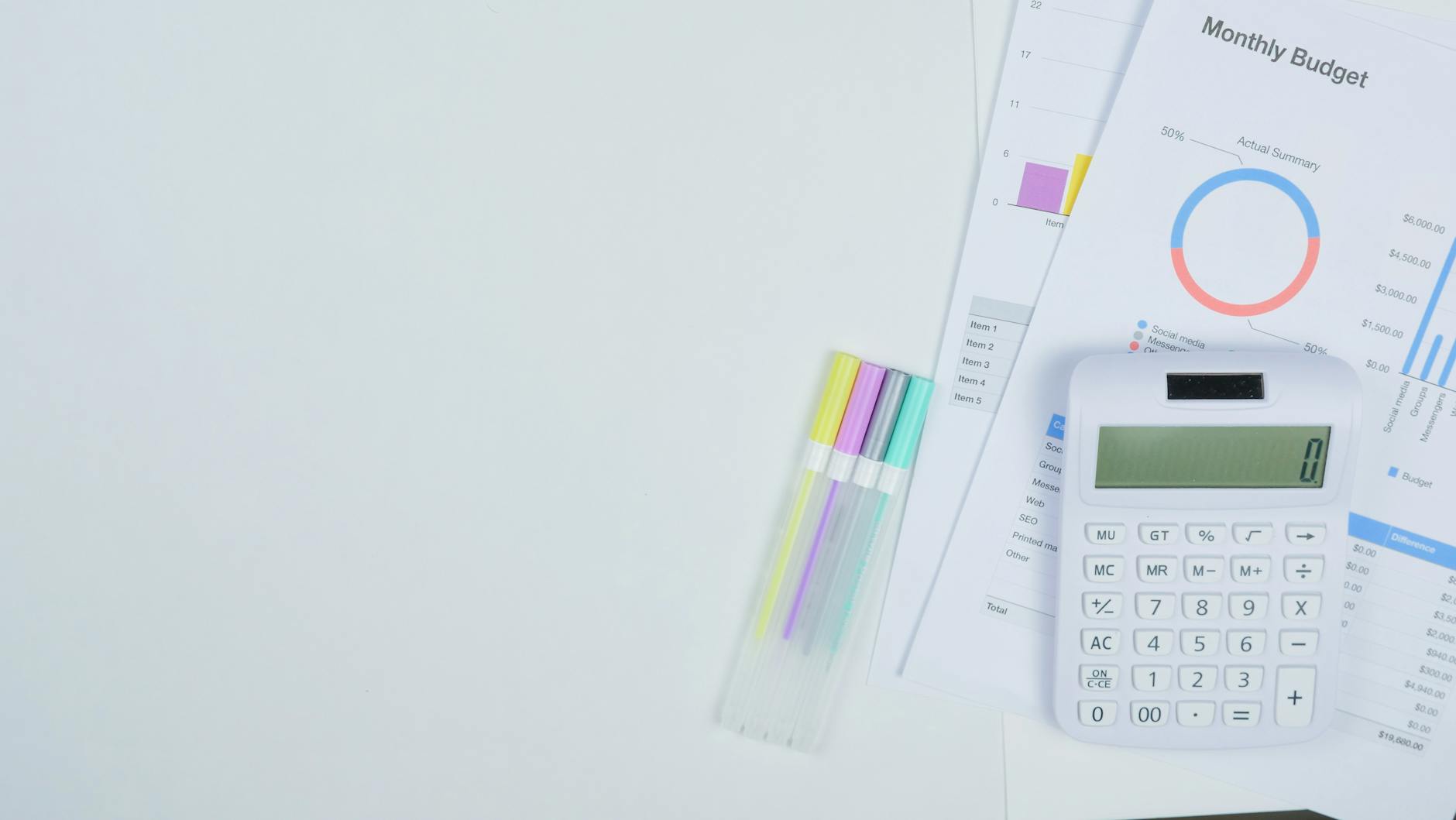 Minimalist office desk with a calculator, budget planning documents, and colorful pens. - budget spring dates