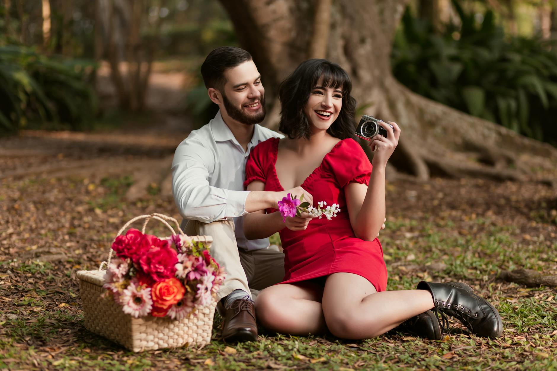 Happy couple having a romantic picnic with flowers in a wooded area. - budget spring dates