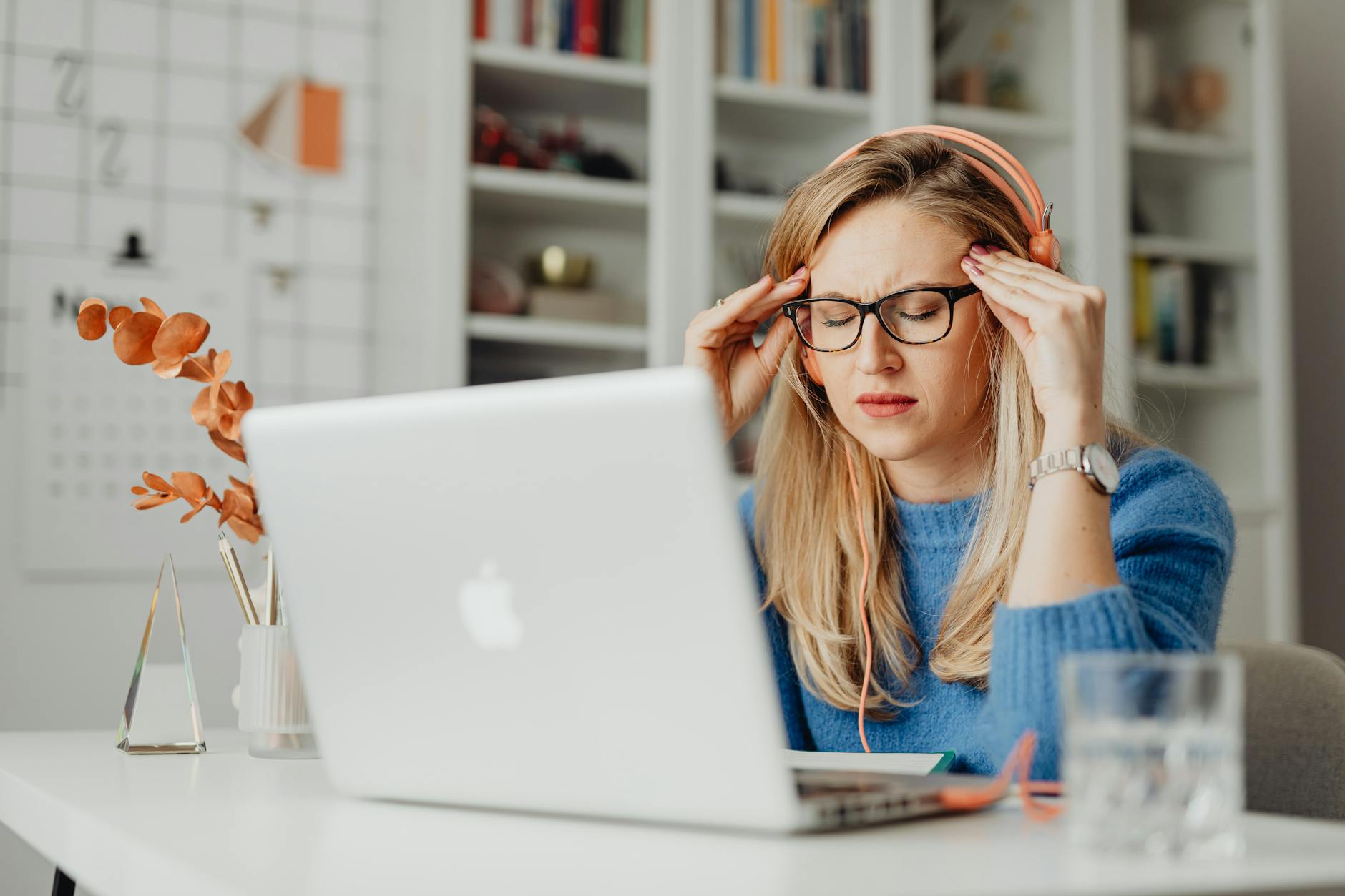A woman experiencing stress while working on a laptop in a home office setting, highlighting a work-from-home lifestyle. - cbt for spring stress