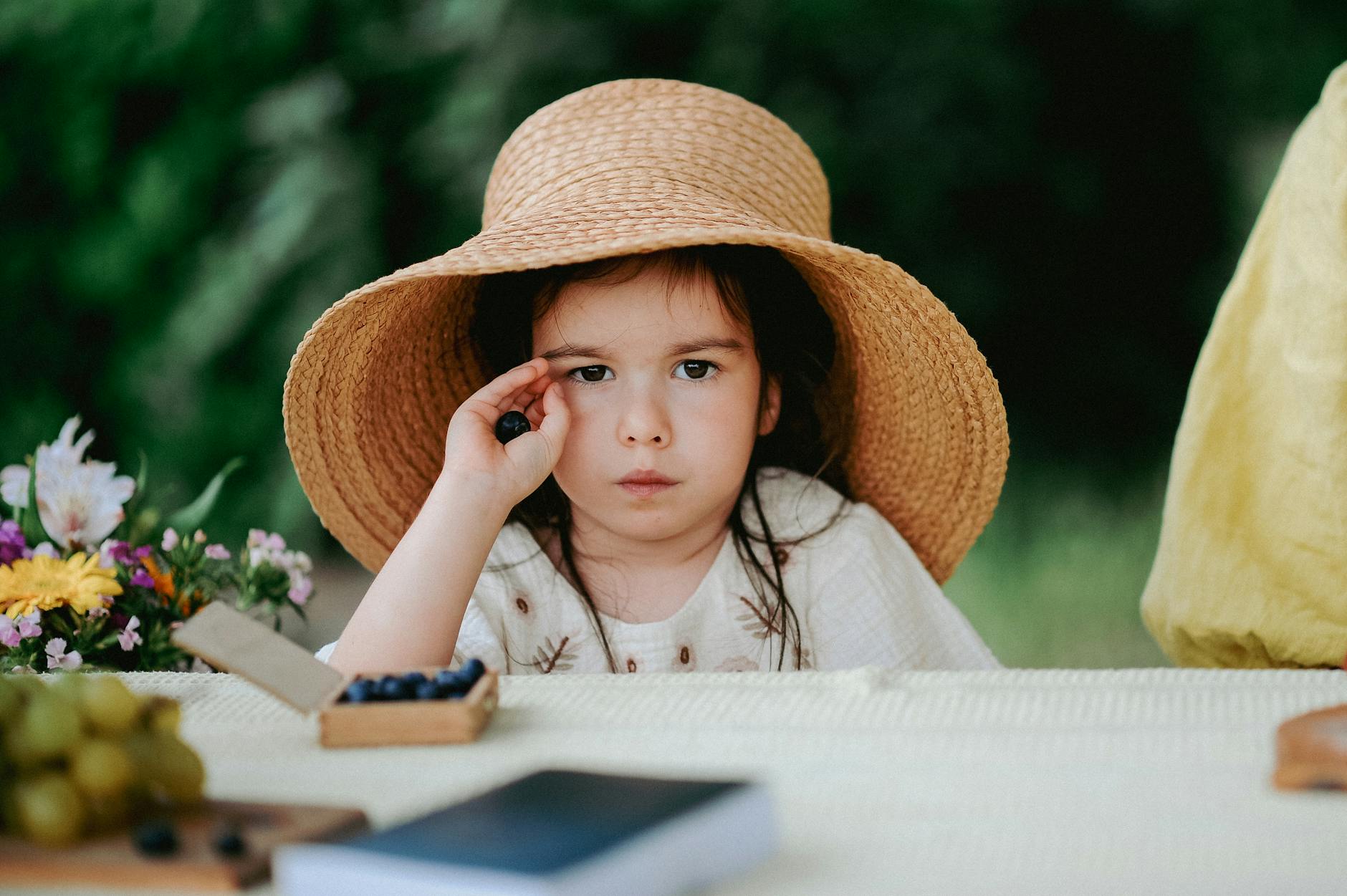 Charming portrait of a young girl in a straw hat, enjoying a summer day with berries. - child resilience summer