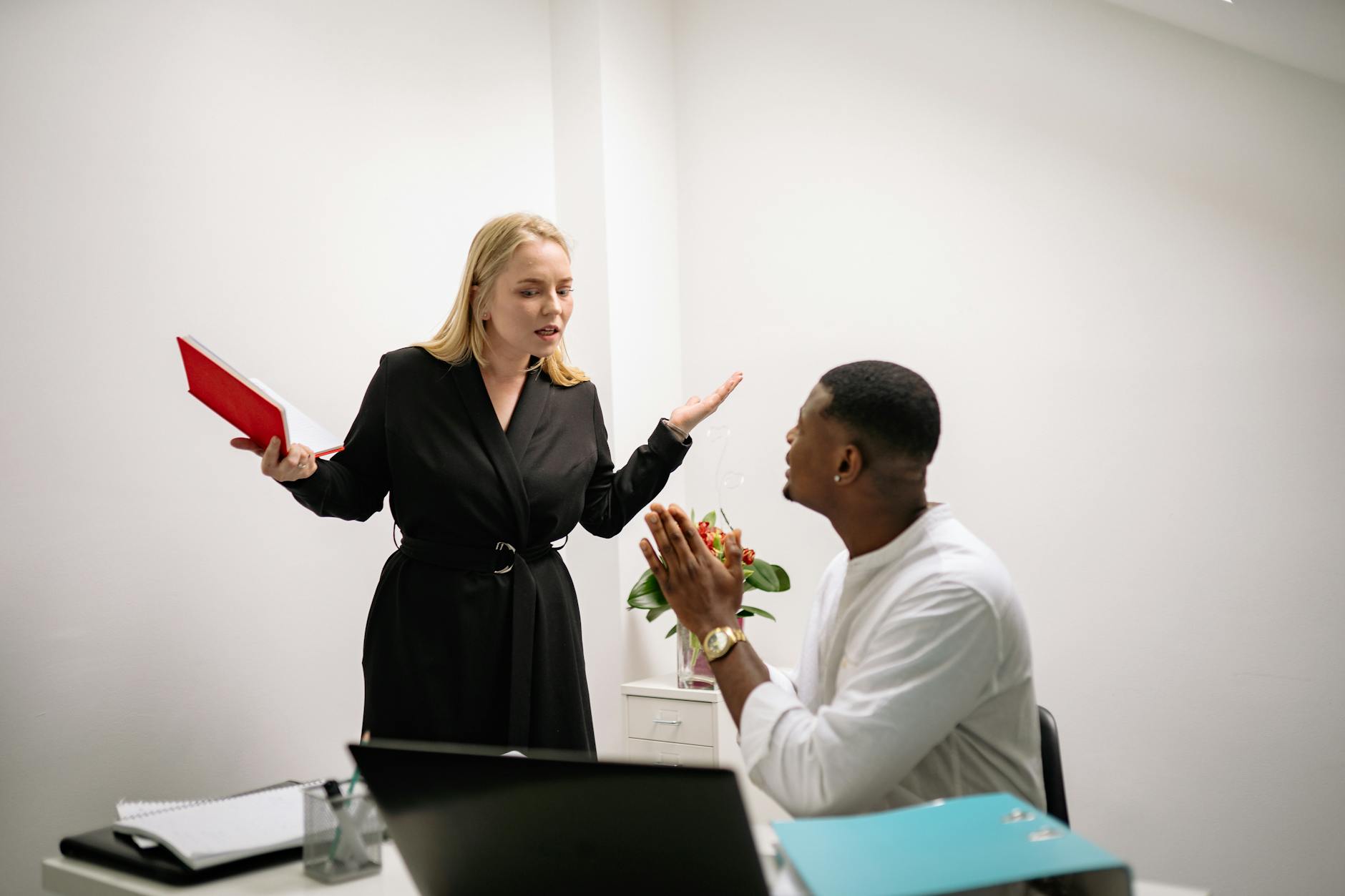 Colleagues in an animated discussion in an office setting, highlighting workplace communication. - conflict resolution worksheet