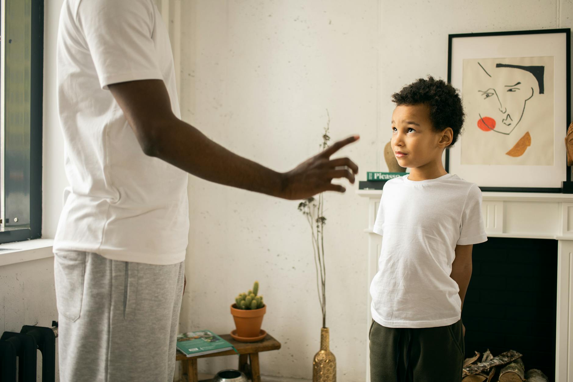 Crop unrecognizable African American father pointing finger and explaining behavior rules to cute guilty son in modern apartment - conflict resolution worksheet
