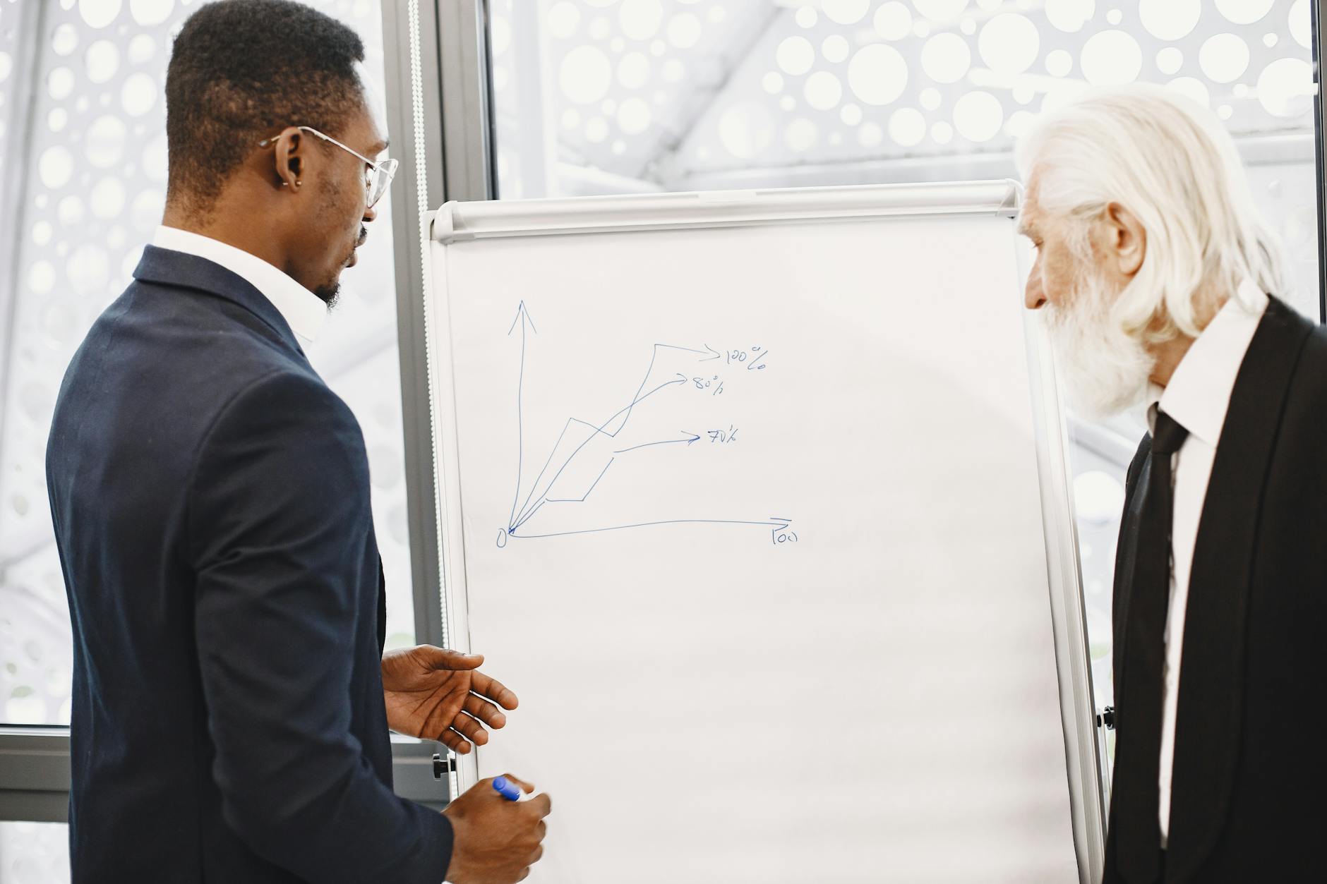 Two businessmen discussing financial charts at an office meeting. - coparenting communication strategies