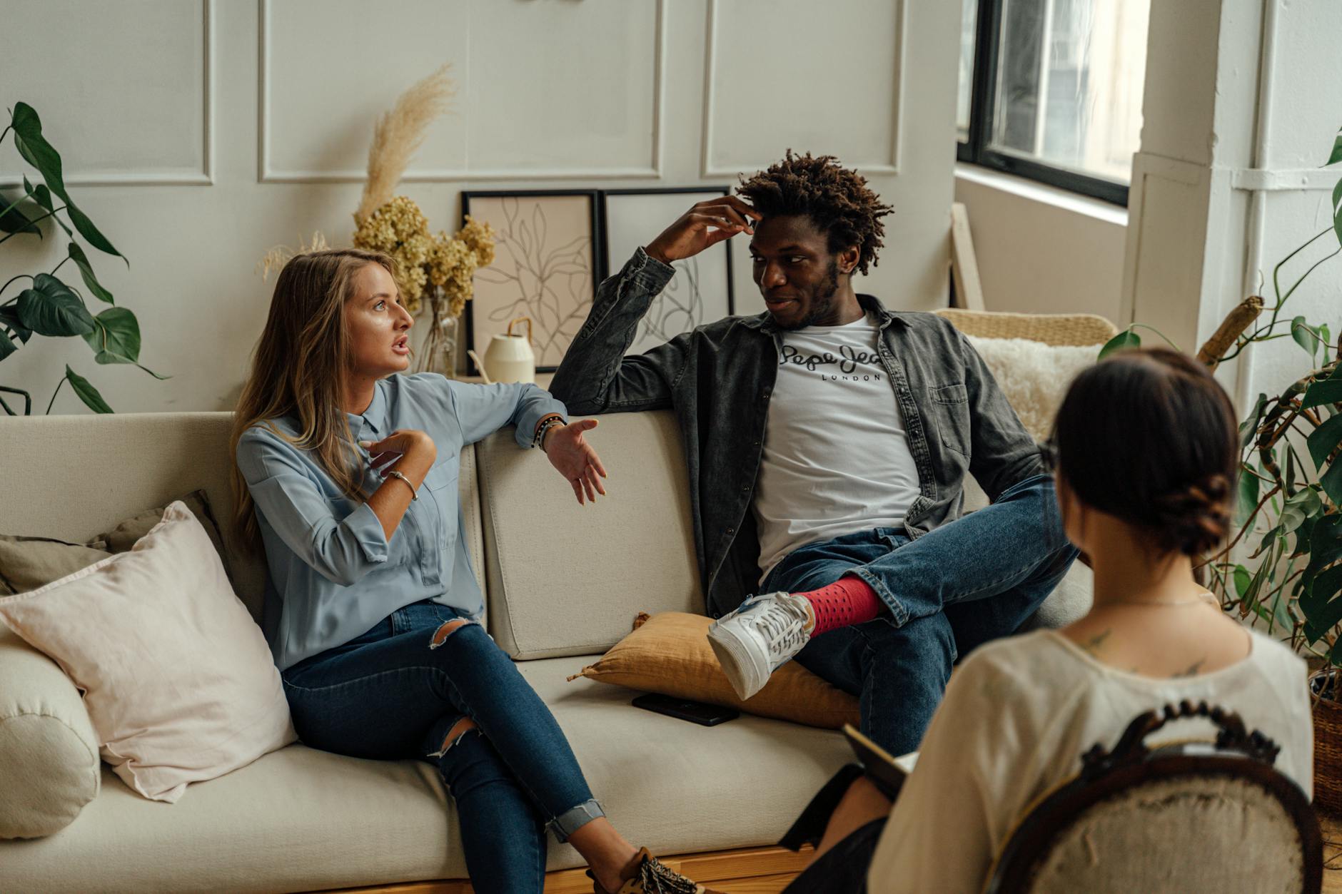 A couple is engaged in a lively conversation during a therapy session with a counselor. - couples therapy goals