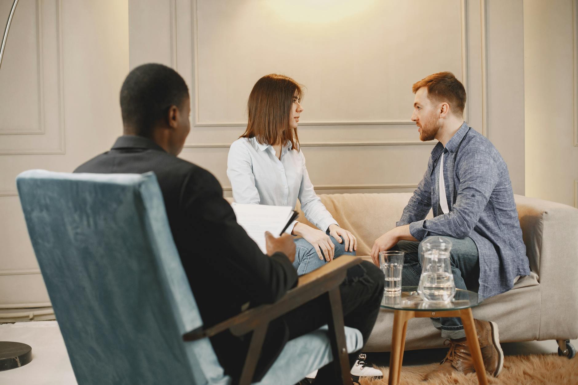 Couple in a counseling session with a therapist in a modern and cozy setting. - couples therapy goals