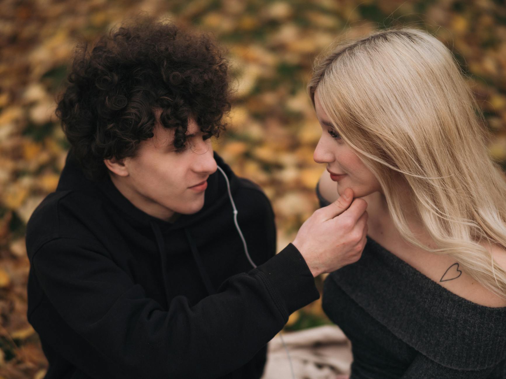 A young couple sharing an intimate moment outdoors during fall. - deep couple communication