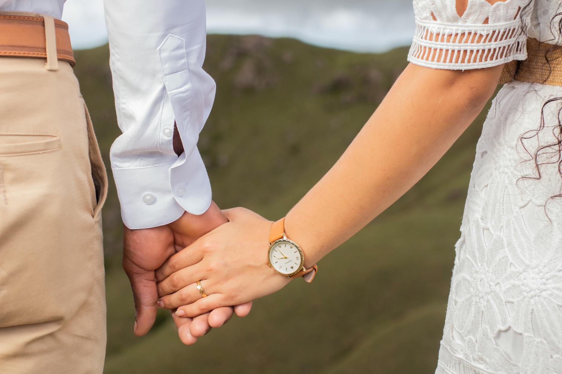 A romantic close-up of a couple holding hands outdoors, symbolizing love and connection. - deepen marriage connection