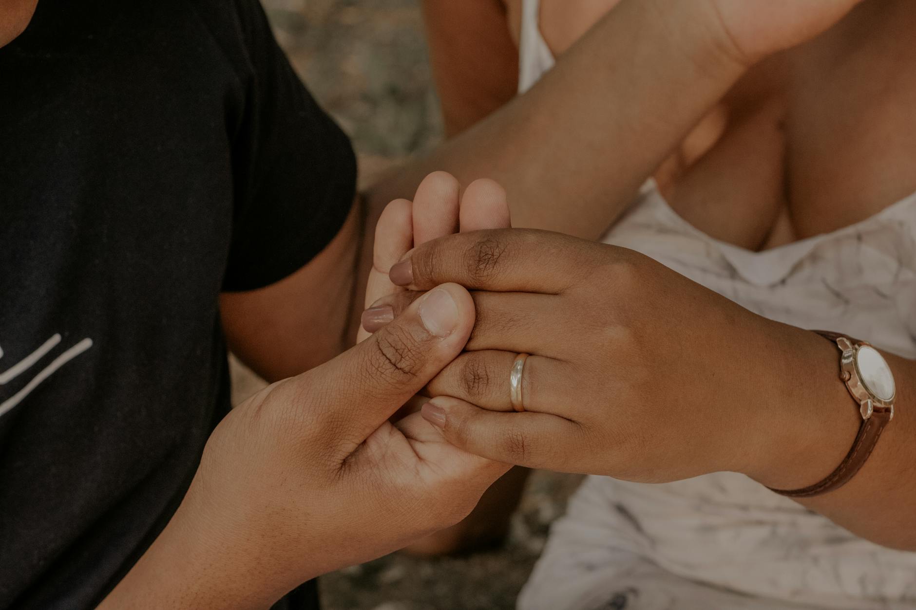 Intimate moment of couple's hands holding each other, showing love and warmth. - early marriage connection