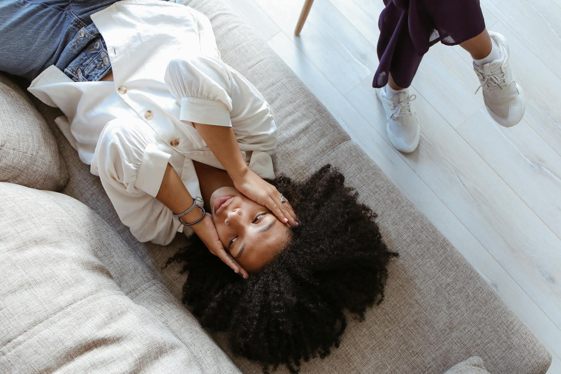 A woman lying on a couch during a therapy session, expressing emotions. - imposter syndrome therapy