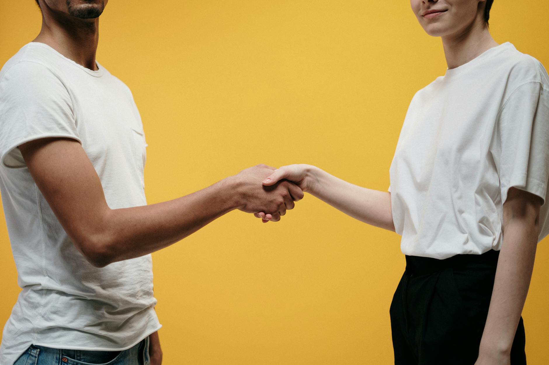 Two people shaking hands symbolizing agreement and partnership. - improve relationship communication