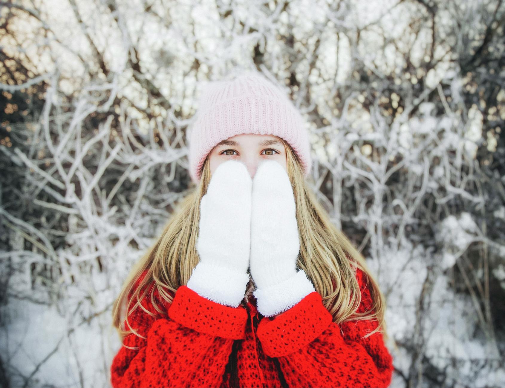 Blonde girl in warm clothing outdoors, enjoying a snowy winter scene. - manage winter anxiety