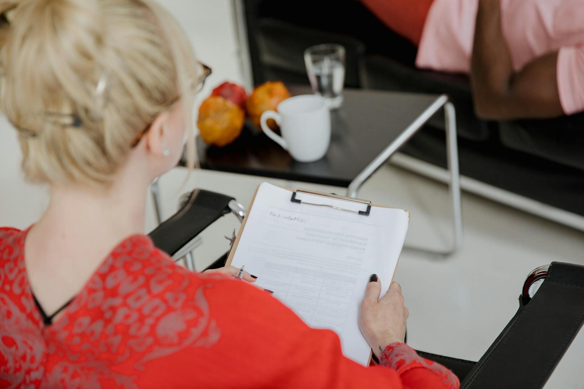 A psychologist takes notes during a therapy session with a client, indoors. - marriage counselor questions