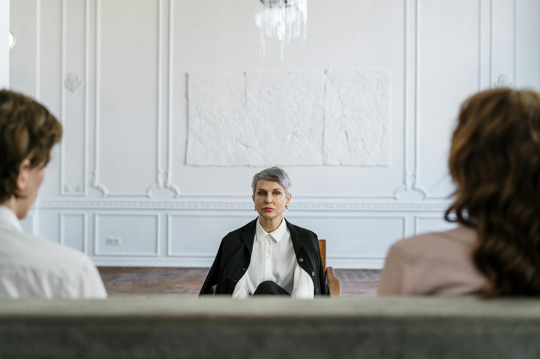 A married couple in a consulting session with a therapist in a modern, minimalistic office. - marriage counselor questions
