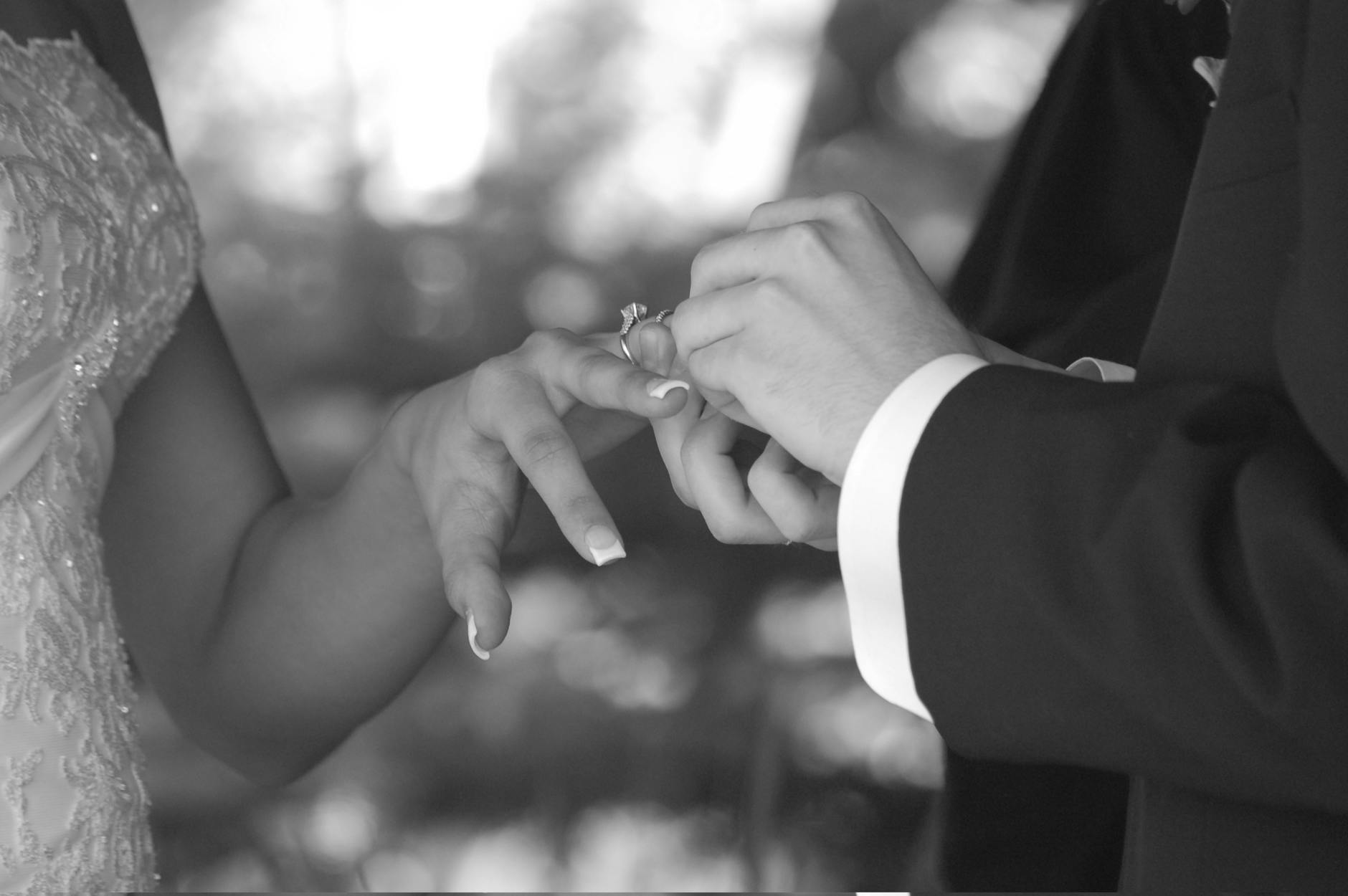 Close-up of a wedding ring exchange in black and white. Captures a timeless, romantic moment. - marriage after winter