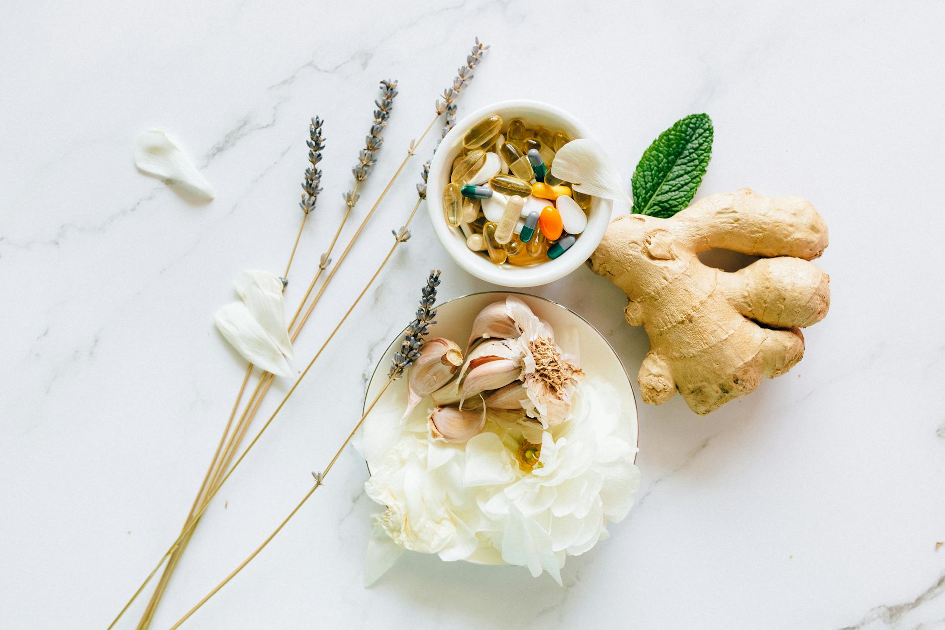 Flat lay of ginger, garlic, flowers, and supplements for holistic health. - natural mood boosters
