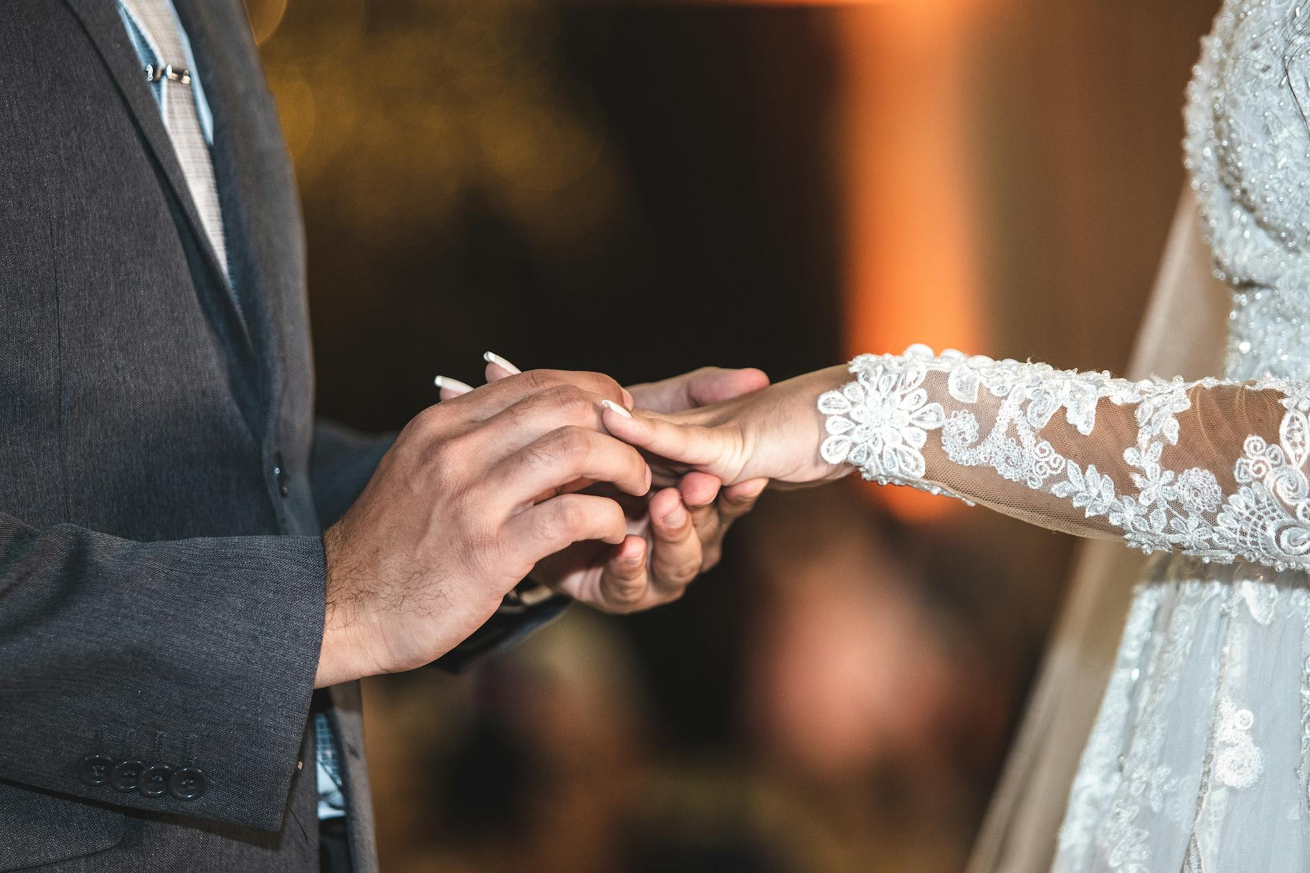 Close-up of a couple exchanging rings during their wedding ceremony, showcasing love and commitment. - new marriage adjustments