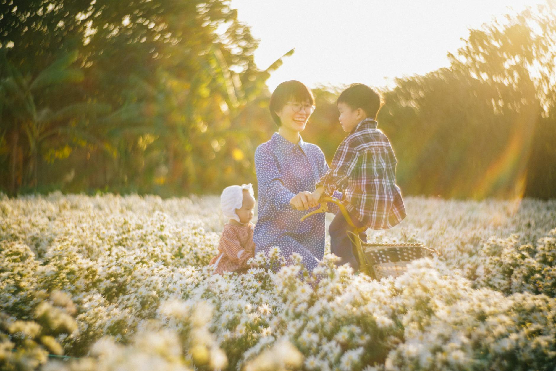 Mother with children enjoying a sunny day in a field of white flowers. Capturing happiness and nature. - parent burnout spring