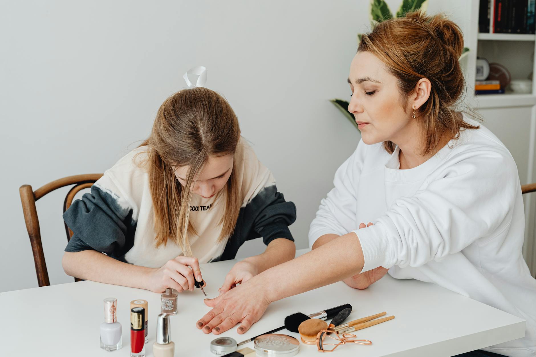 A mother and daughter enjoying a manicure session at home, showing bonding and relaxation. - parental burnout self care