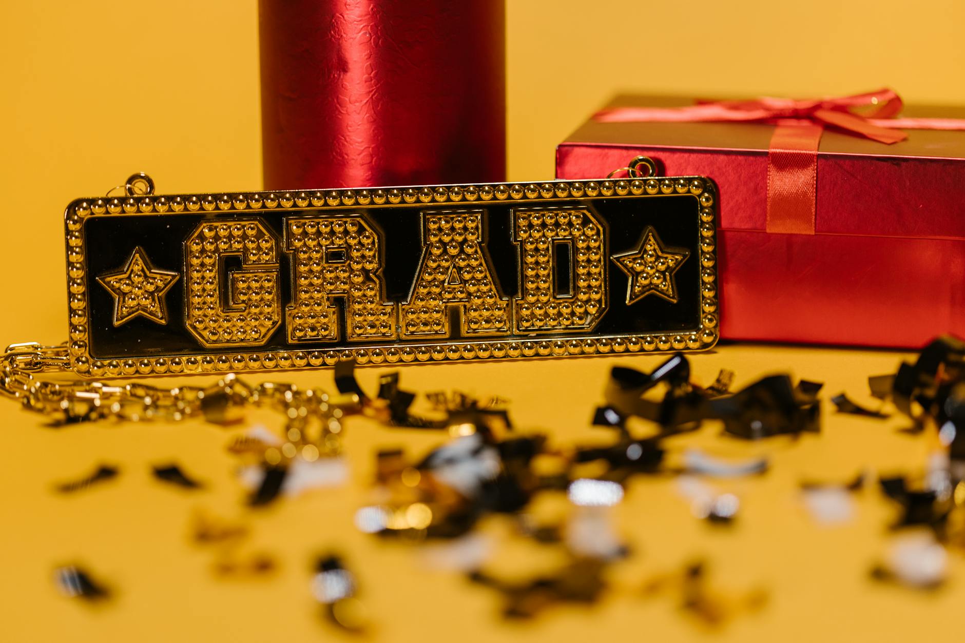 Graduation celebration with a grad sign, gift box, and confetti on vibrant background. - post grad adjustment