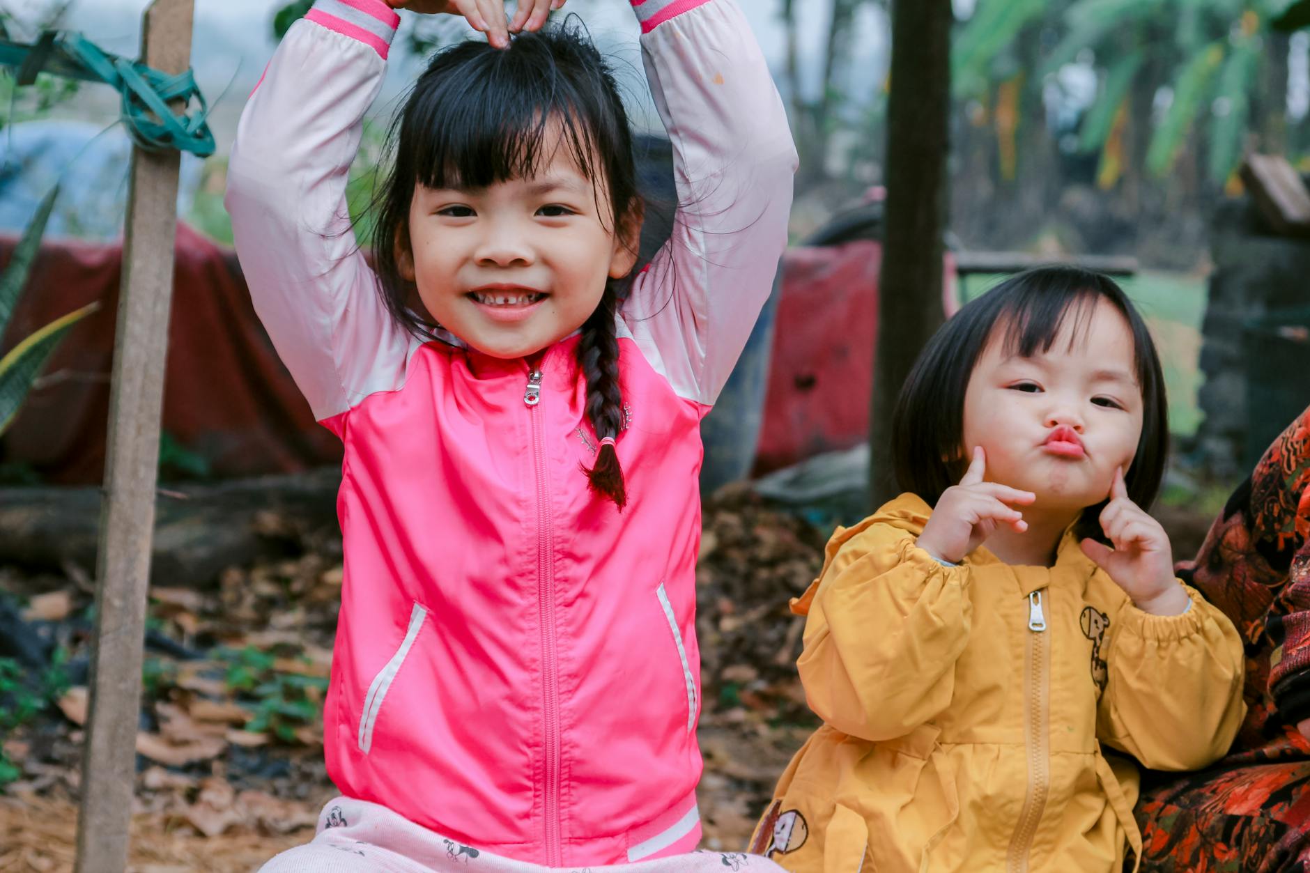 Cheerful young girls in playful poses outdoors in autumn scene. - preschool boundaries outdoors