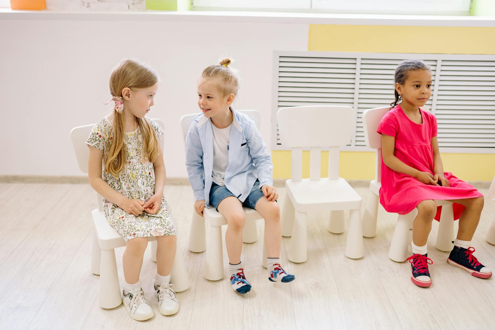 Young children interact and socialize indoors in a kindergarten classroom setting. - preschool boundaries outdoors