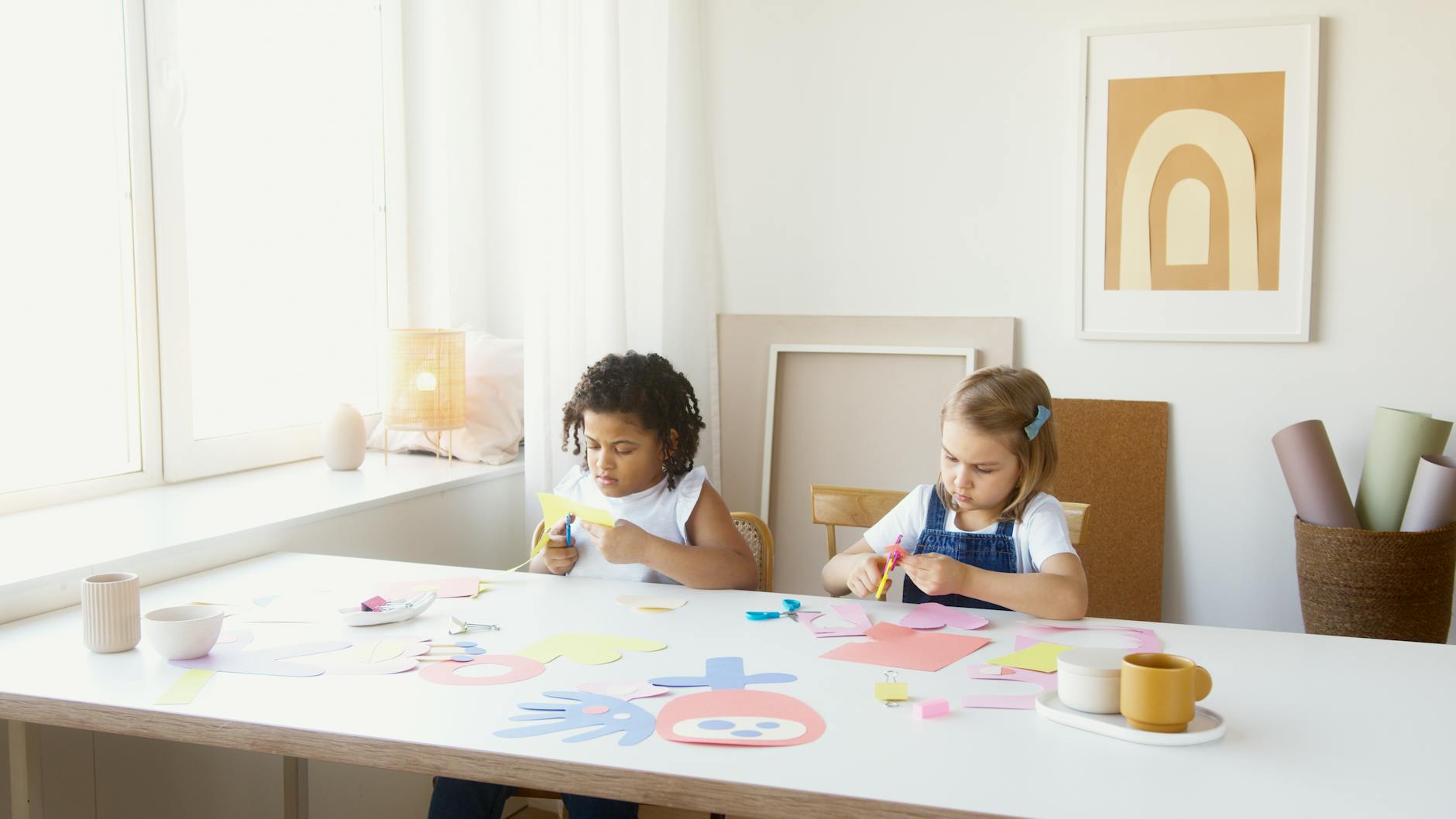 Two young children enjoy cutting colorful paper during an art class indoors, fostering creativity and learning. - preschool playdate ideas