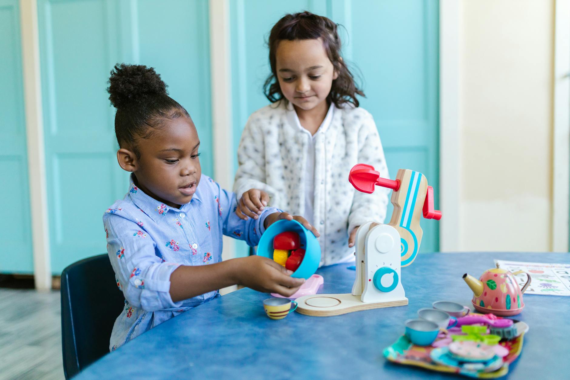 Two young girls playing and learning with toys in a classroom setting. - preschool sharing activities