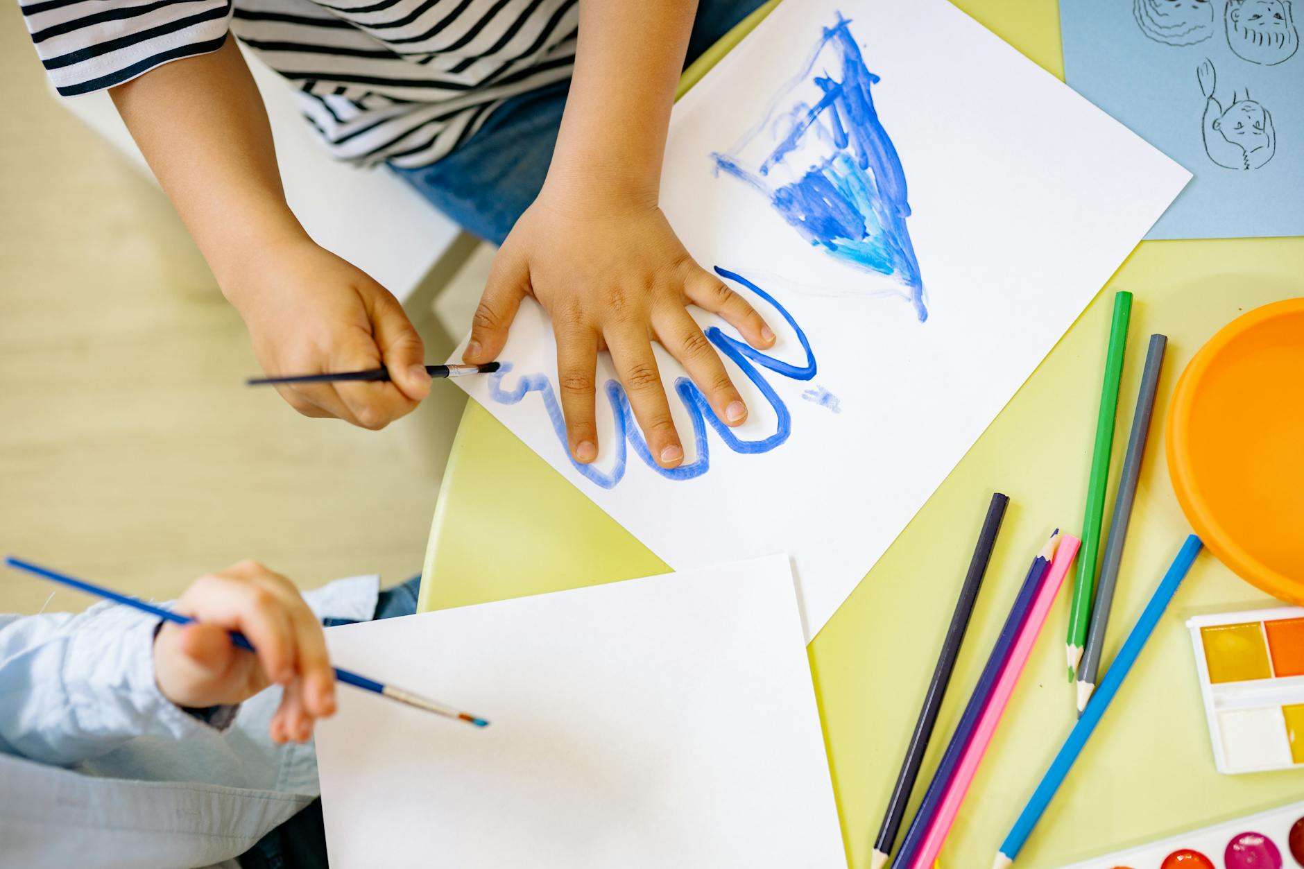 Children painting with watercolors and colored pencils, fostering creativity and learning in a fun environment. - preschooler self identity