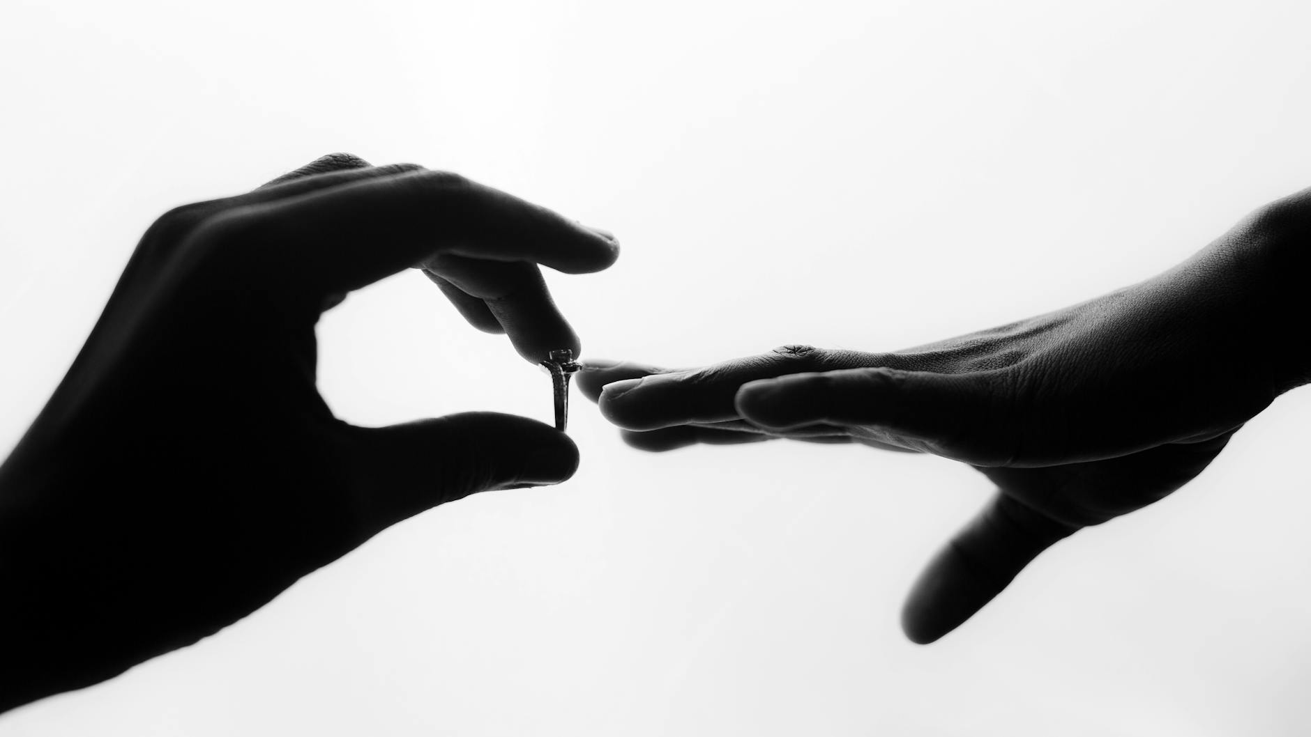 Artistic black and white silhouette of a wedding ring being placed on a finger, symbolizing marriage. - rekindle marriage connection