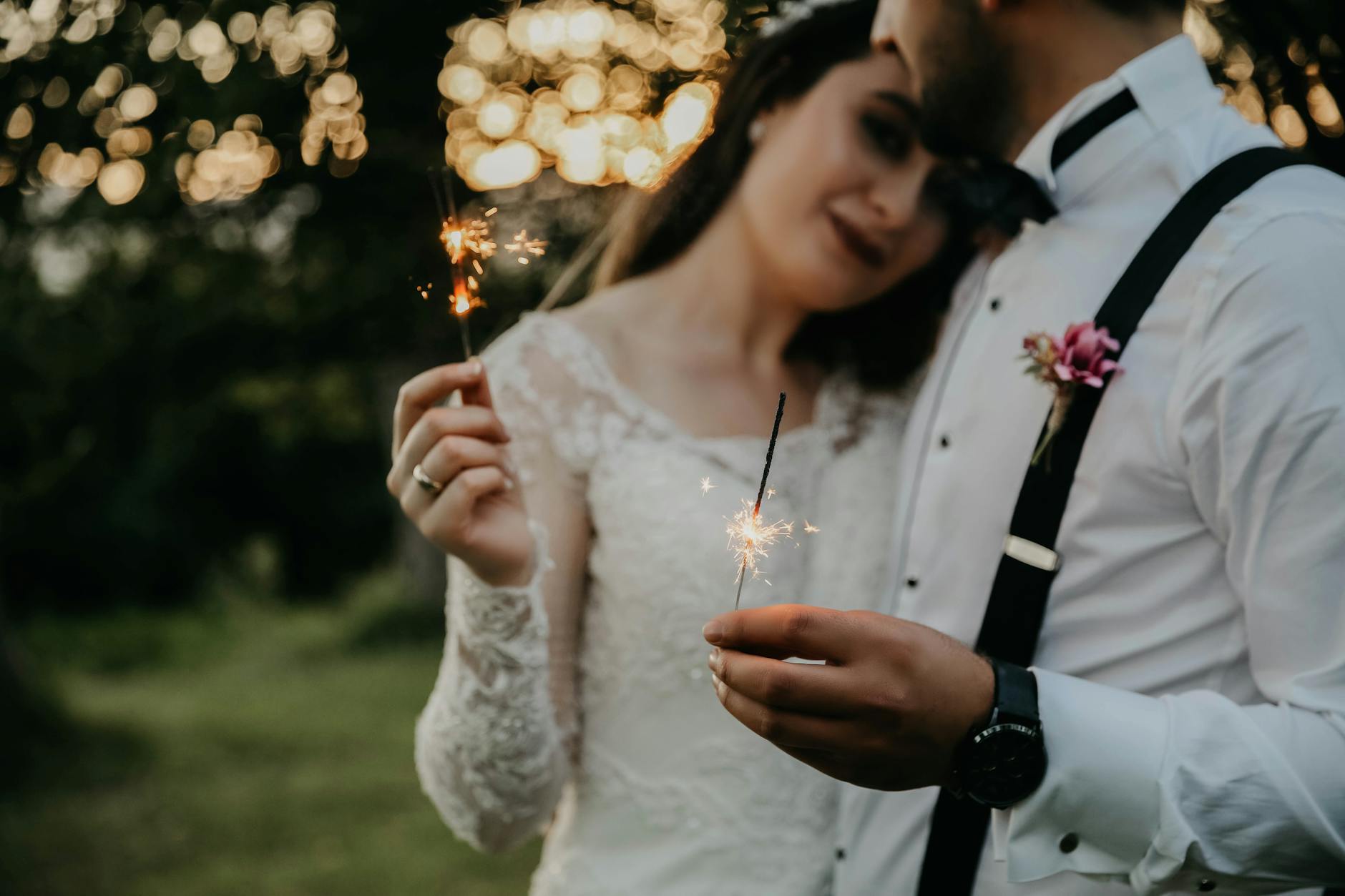 Couple celebrating their wedding outdoors with sparklers, creating a romantic scene. - rekindle marriage connection