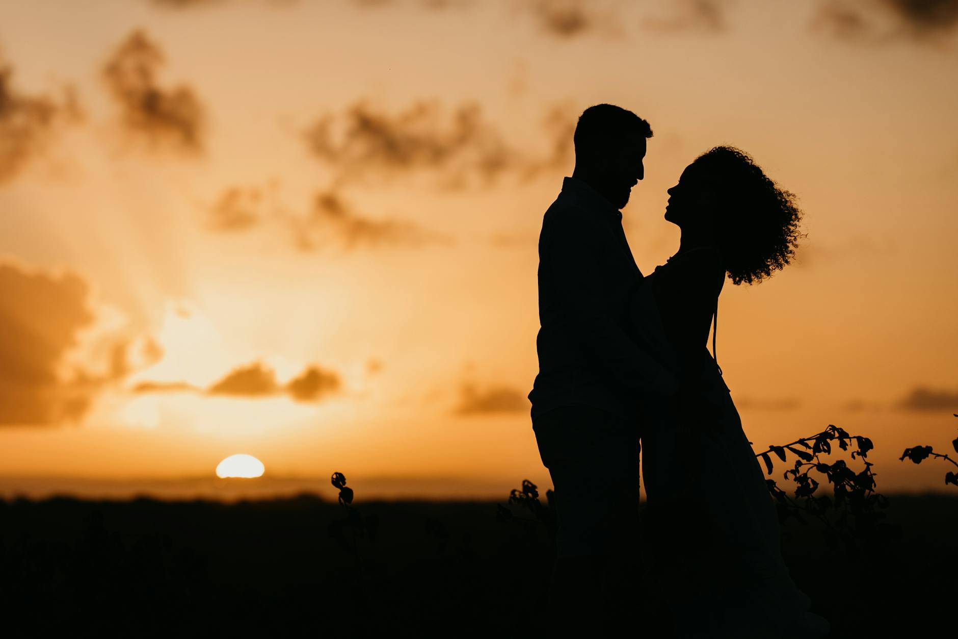 Silhouette of a couple embracing as the sun sets, capturing a romantic and serene moment. - rekindle relationship passion