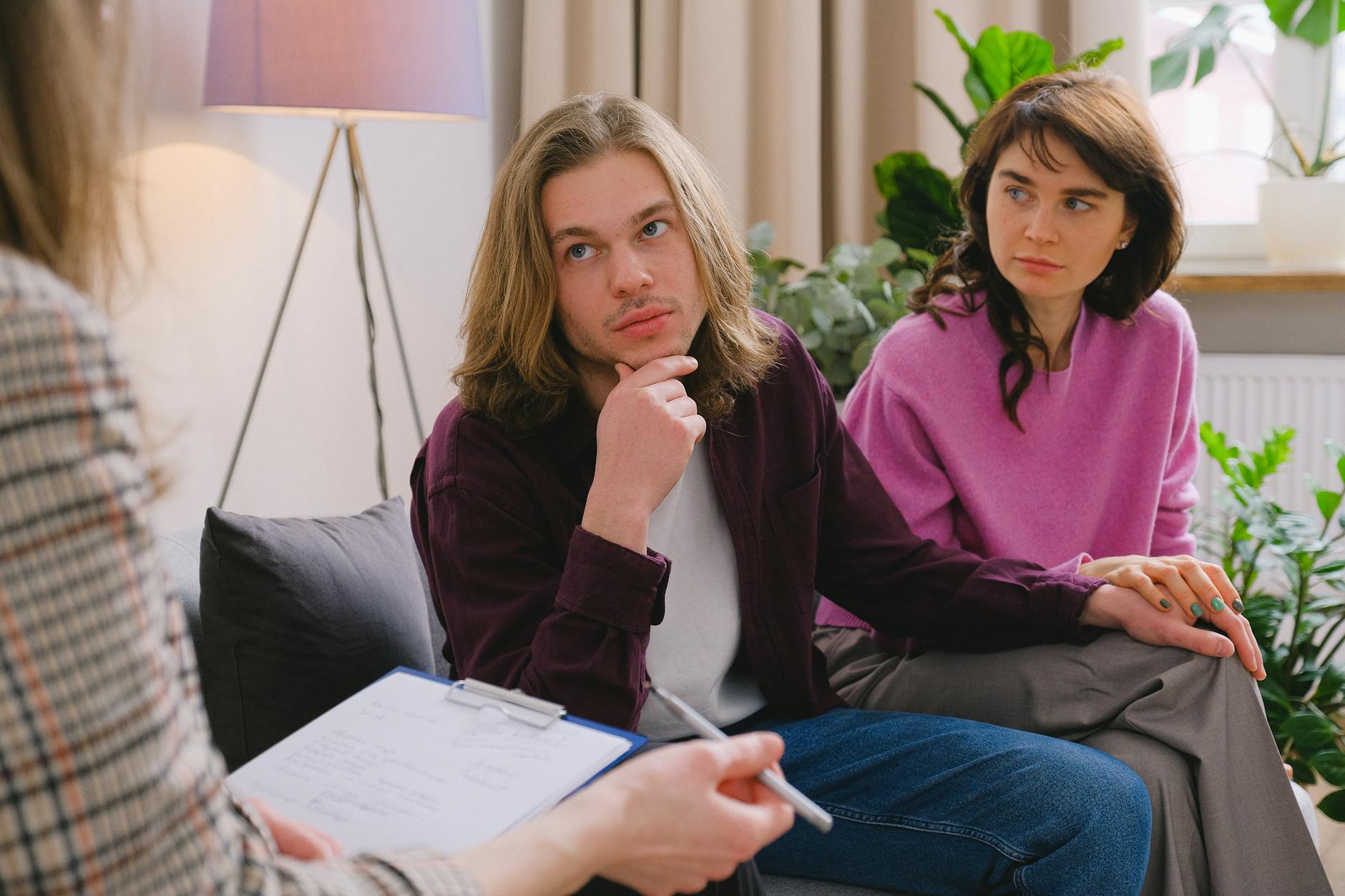A couple holding hands during a therapy session in an office setting. - relationship boredom therapy