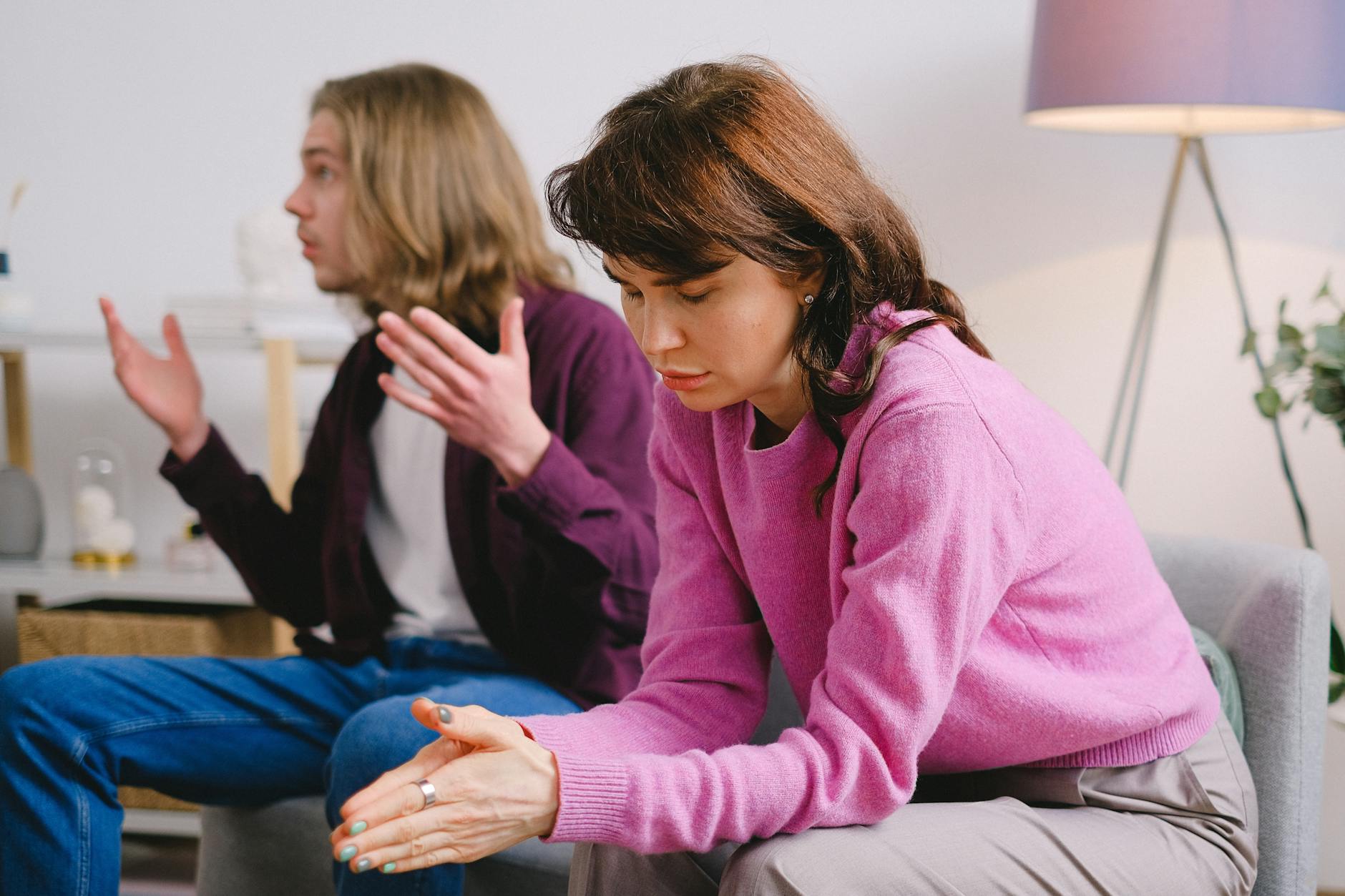 A couple having a serious discussion indoors; one looks upset while the other gestures expressively. - relationship conflict spring