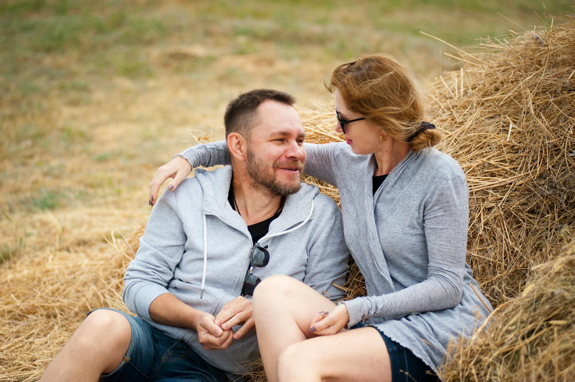 A joyful couple embraces in a sunlit field, enjoying summer leisure time together. - relationship renewal ideas