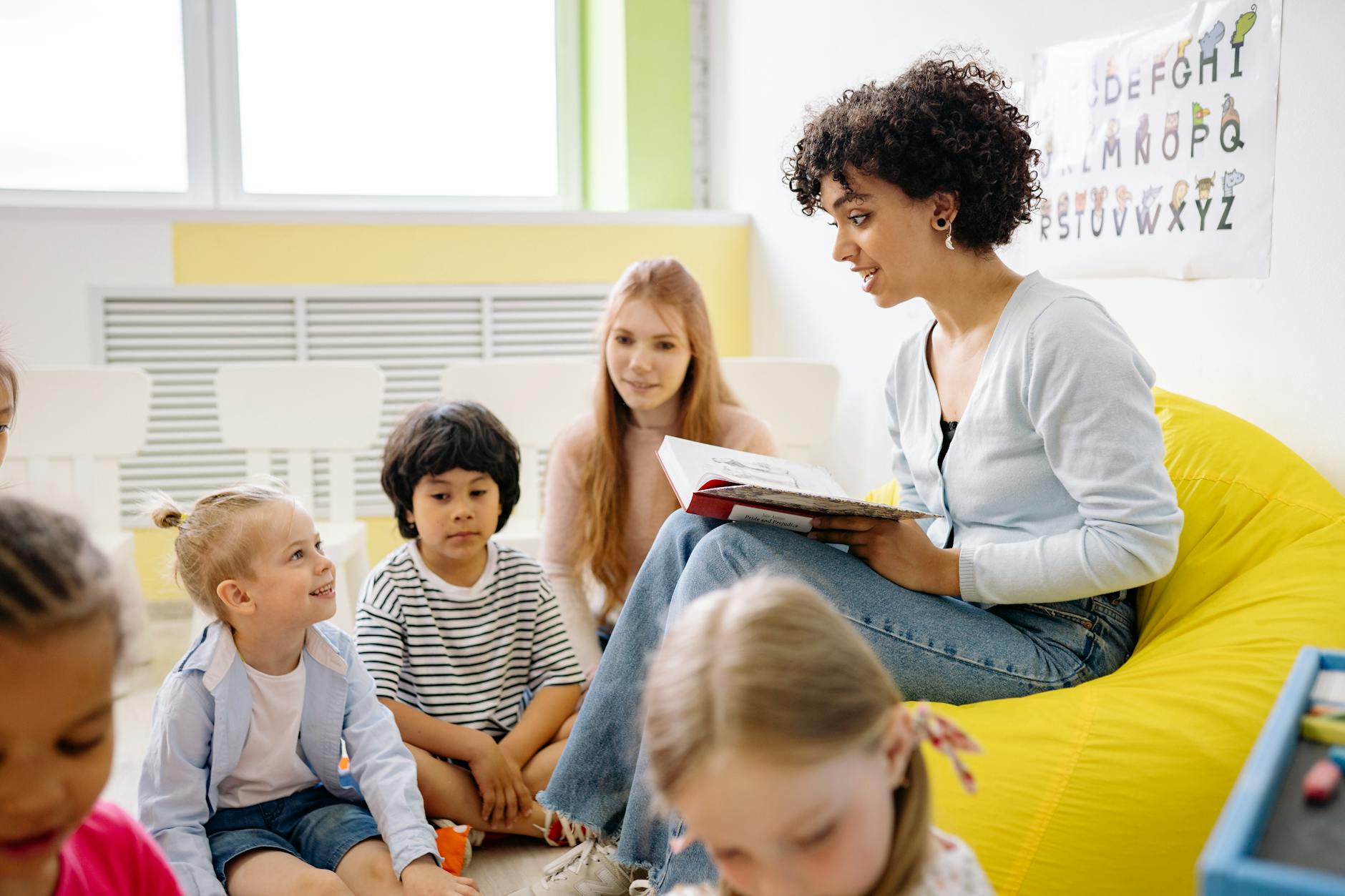 Teacher reading to preschool kids in a colorful classroom setting. - teach empathy preschoolers