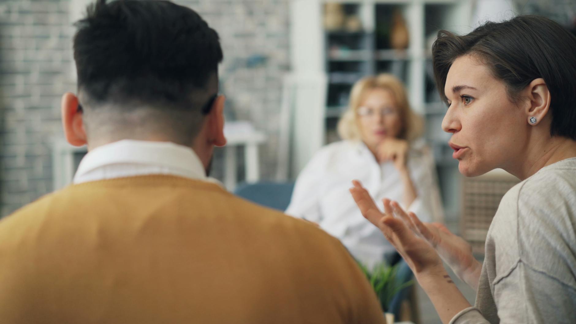 A therapist conducting a counseling session with a couple in an office setting. - therapist for relationship anxiety