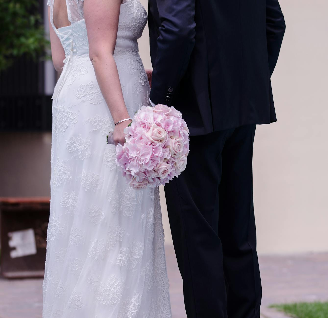 Bride and groom holding a pink rose bouquet, showcasing love and elegance in a wedding setting. - wedding day anxiety
