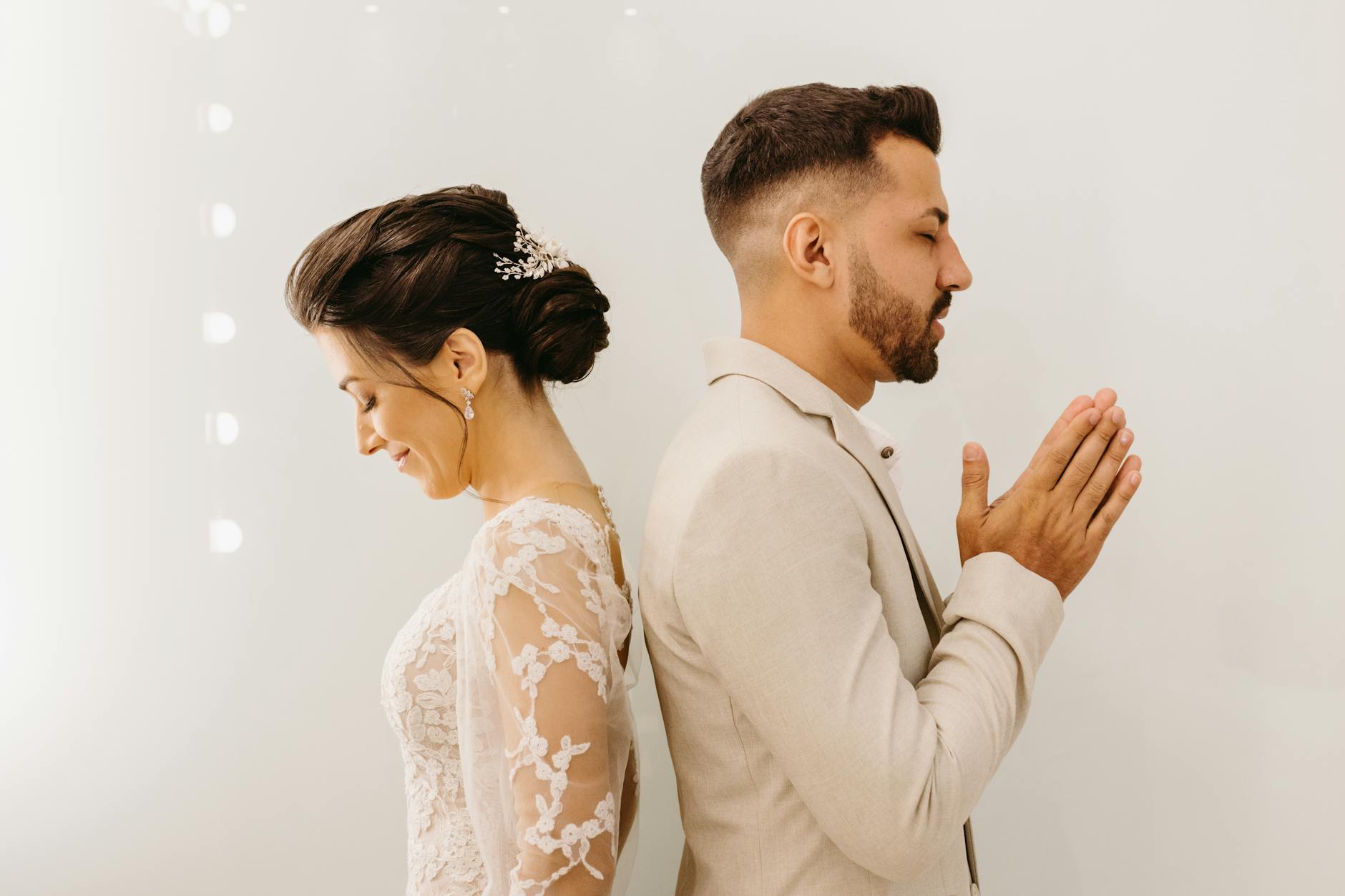 Bride and groom share a tender first touch moment before their wedding ceremony, emphasizing elegance and romance. - wedding stress management