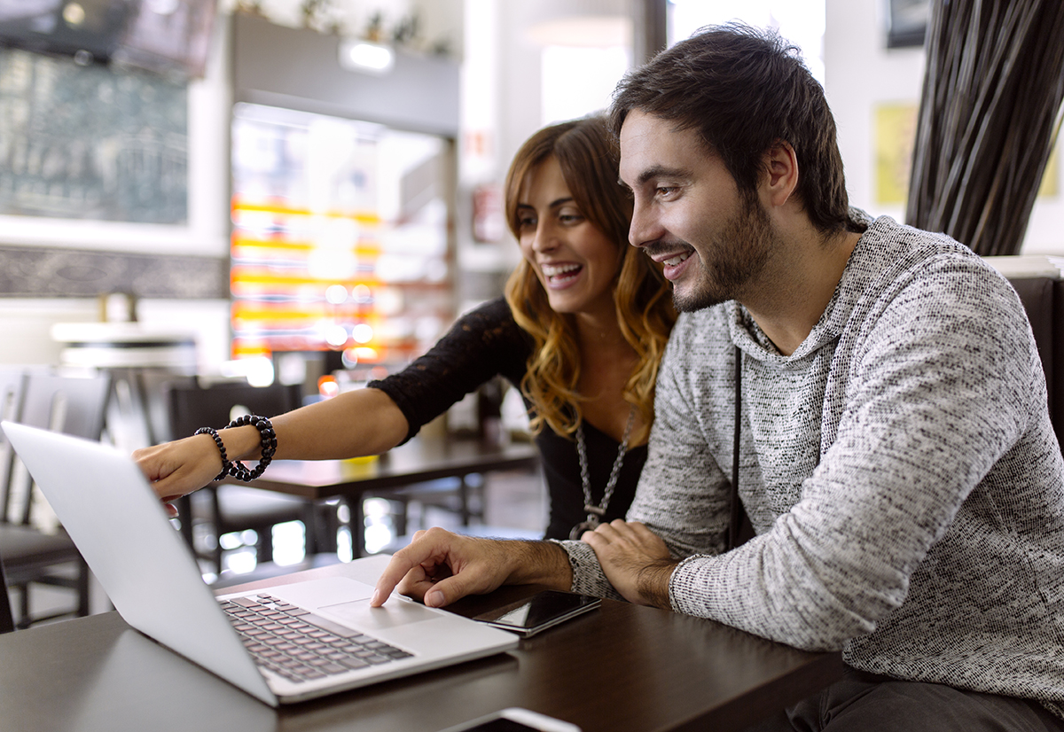 Couple joyfully interacting with social media, representing the impact of social media on relationships.