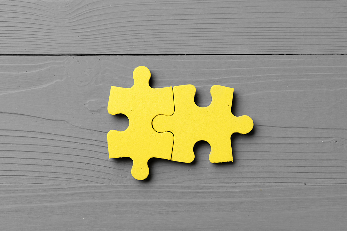 Two unique puzzle pieces fitting together, representing individuality in a relationship