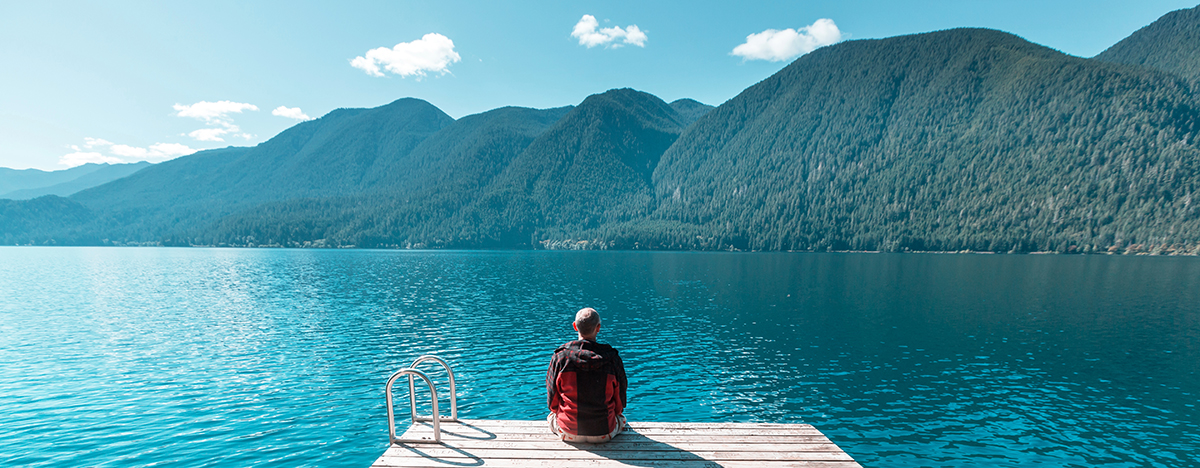 Person experiencing the benefits of self-love, portrayed through a serene landscape