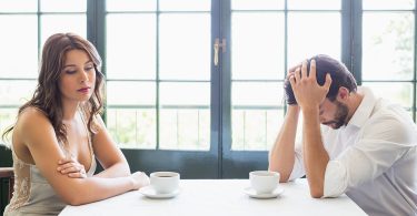 Depressed couple sitting with coffee cup in the restaurant