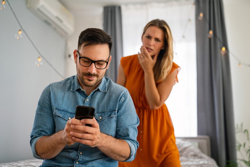 Jealous young woman spying boyfriend