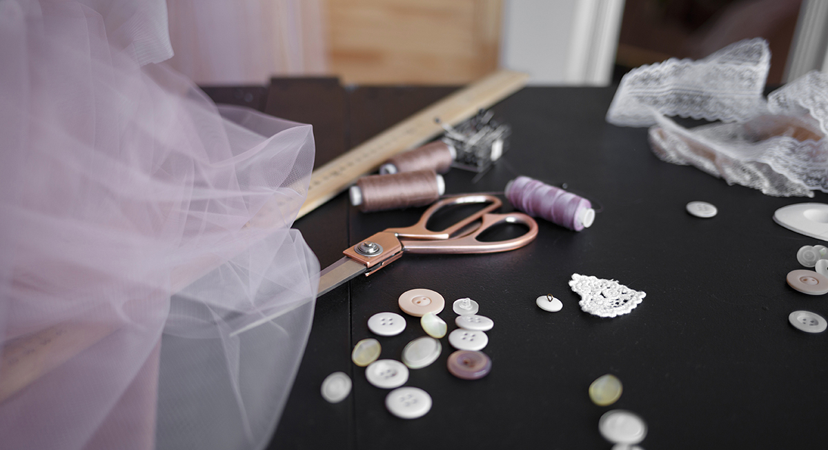 A tailor's table with fabrics and sewing tools, symbolizing the tailored strategies essential for relationship revival.