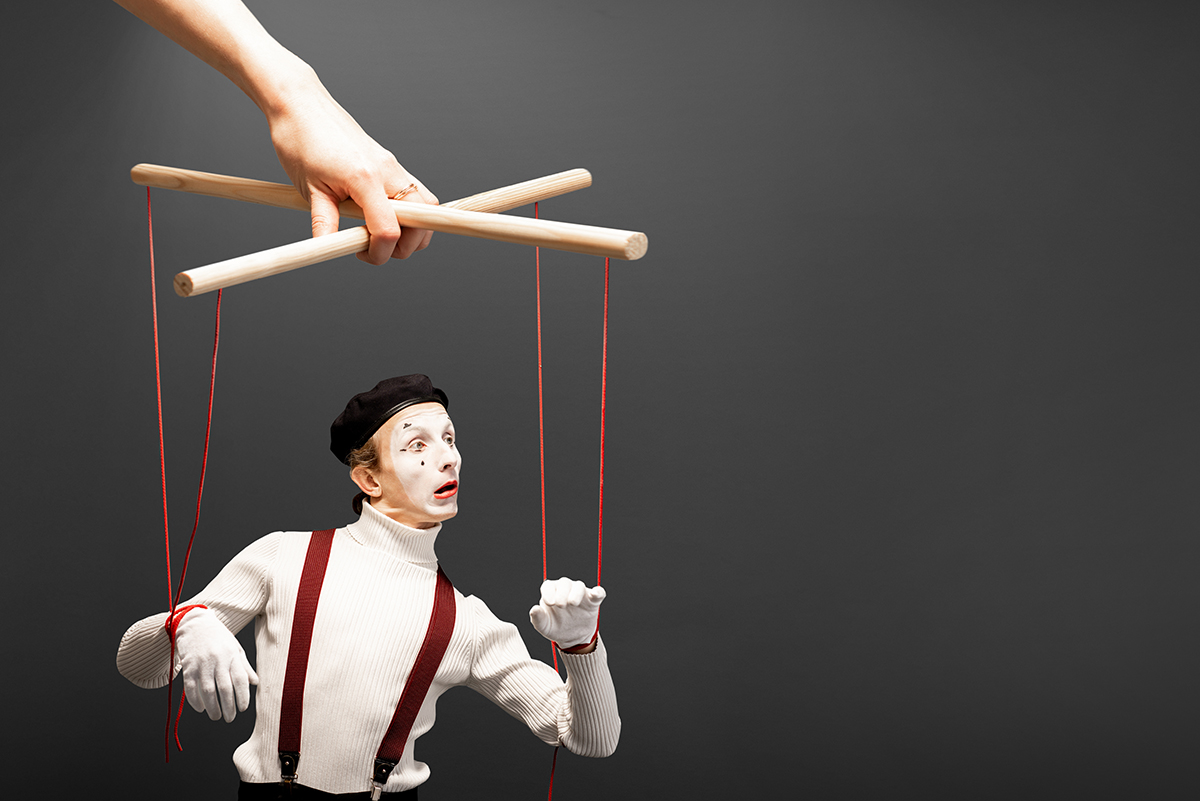 A marionette controlled by a hand, symbolizing the manipulation in narcissistic abuse