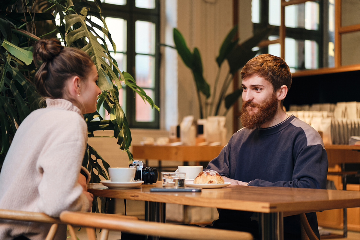 Two people engaged in a deep conversation over coffee, symbolizing the process of getting to know someone before dating.