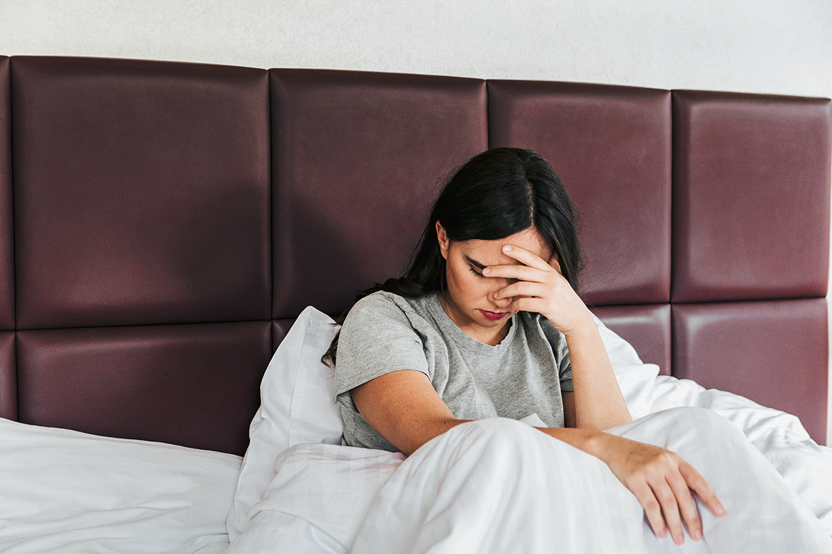 Woman experiencing sleeping problems in bed, possibly due to overthinking relationship issues.