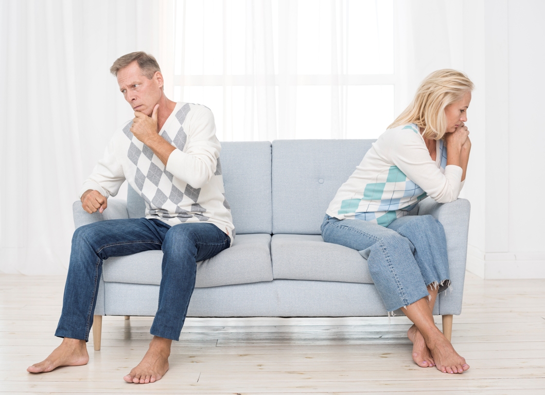 Couple sitting apart, experiencing communication breakdown